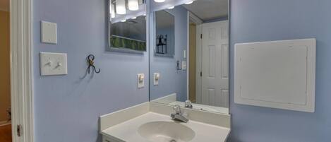 A bathroom with a sink, mirror, and light fixtures.