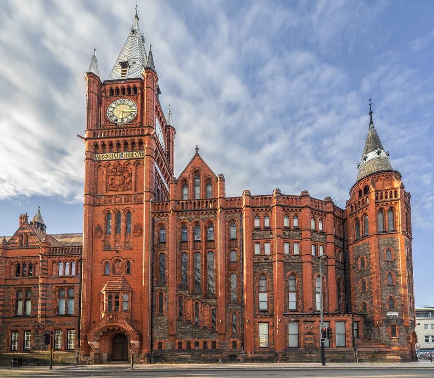 A large, historic building with a prominent clock tower and arched windows.