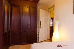 A bedroom with a wooden wardrobe, a white door, a bedside lamp, and a bed with floral bedding. - SAFE & QUIET APARTMENT, FAST WIFI ! - CENTRE /UNIVERSITY (Liverpool)