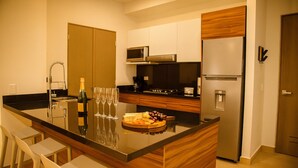 A modern kitchen with a central island, stainless steel appliances, and wooden cabinetry.