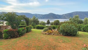 A garden with a view of mountains and a lake. - Seafront Holiday Villa (Skroponeria Politeia)
