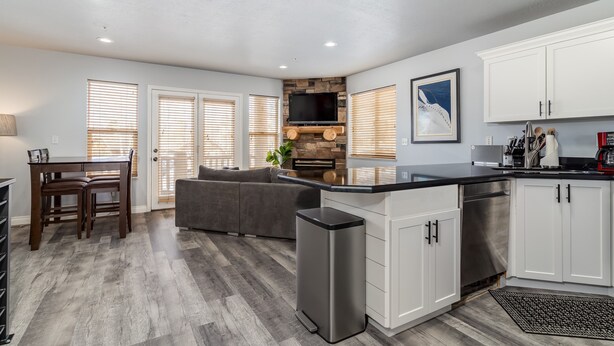 A modern kitchen with white cabinets, a built-in stove, and a large island. - Stay cool with great rates and central Air conditioning! Weber County lic #3495 (Eden)