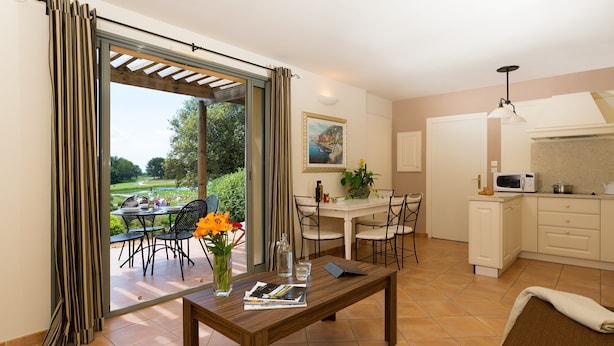 Comedor con una mesa, sillas y vistas a un jardín.