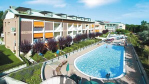 Ein Hotel mit Schwimmbad, Außenbereich und einem gepflegten Garten.