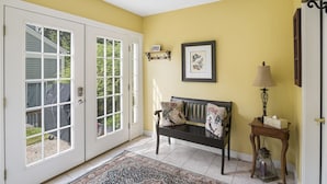 A hallway with a bench, a rug, a lamp, and a framed picture on the wall. - Topnotch Resort Home - Private Hot Tub (Stowe)
