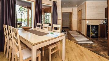 Una mesa de madera para comer con sillas, un tapete y vistas al exterior.