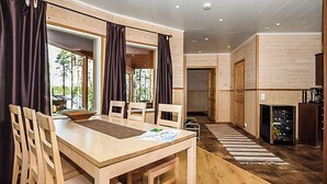 Ein Holzespeisesaal mit Stühlen, einem Teppich und Blick ins Freie.
