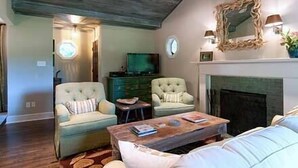 A living room with a fireplace, two armchairs, a coffee table, and a television. - Relaxing Stay in Black Mountain, NC (Black Mountain)