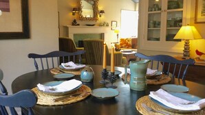 A dining table set with placemats, plates, and cutlery. There are chairs around the table, and a ceiling fan above. - Relaxing Stay in Black Mountain, NC (Black Mountain)