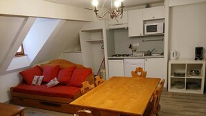 A compact kitchen with white cabinets, a microwave, and a coffee maker. - 2-Room Apartment for 6 with Pool (Vignec)