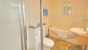 Une salle de bain avec une douche à parois de verre, une baignoire, des toilettes et un lavabo.
