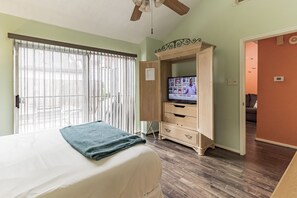 Relax in this serene space with a large bed, a flat-screen TV, and a wardrobe with a mirror.