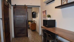 A kitchen with a sliding door, a microwave, and a bar stool.