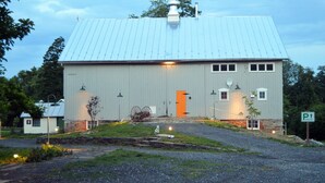 Un grand bâtiment d’un seul étage, doté d’un toit en métal et d’une porte orange bien visible.