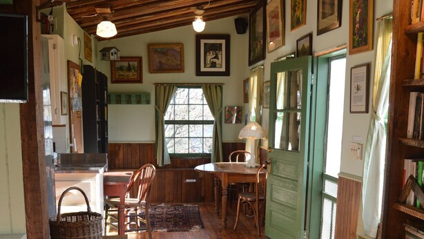 Un intérieur rustique avec des planchers en bois, un coin repas et une bibliothèque.
