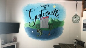 Une fresque murale accueillant les visiteurs de Cybersville avec une canne à pêche, des arbres et une lune.