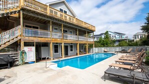 A two-story building with a pool and outdoor seating. - Oceanside, Pool, Hot Tub, Close to Beach, OH1, Silver Sandcastle (Corolla)