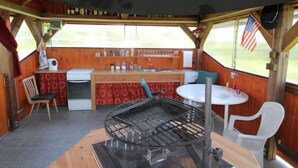 A compact kitchen with a stove, sink, and a small dining area with a table and chairs. - Rokytnice v Orlických horách by Interhome (Rokytnice v Orlickych horach)