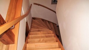 A wooden staircase with a curved handrail and a light-colored wall. - Rokytnice v Orlických horách by Interhome (Rokytnice v Orlickych horach)