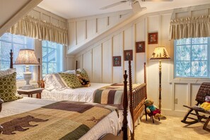 Un dormitorio con una cama grande, una mecedora y una ventana con persianas.