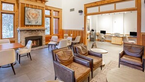 A spacious lobby with a fireplace, comfortable seating, and a reception area with computers and a cash register.