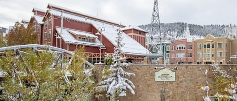Un hotel Marriott con entrada de pared de piedra, un paisaje cubierto de nieve y una montaña al fondo.