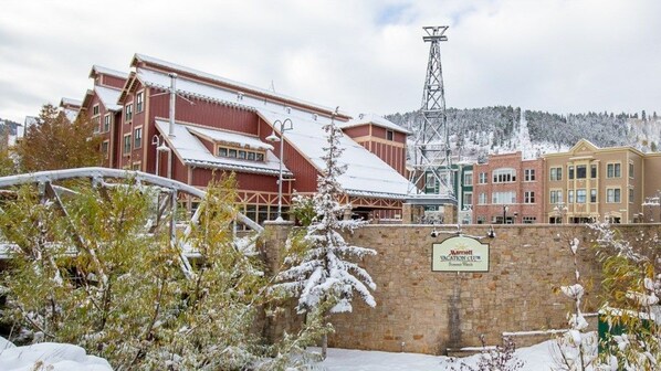 A Marriott hotel with a stone wall entrance, a snow-covered landscape, and a mountain in the background.