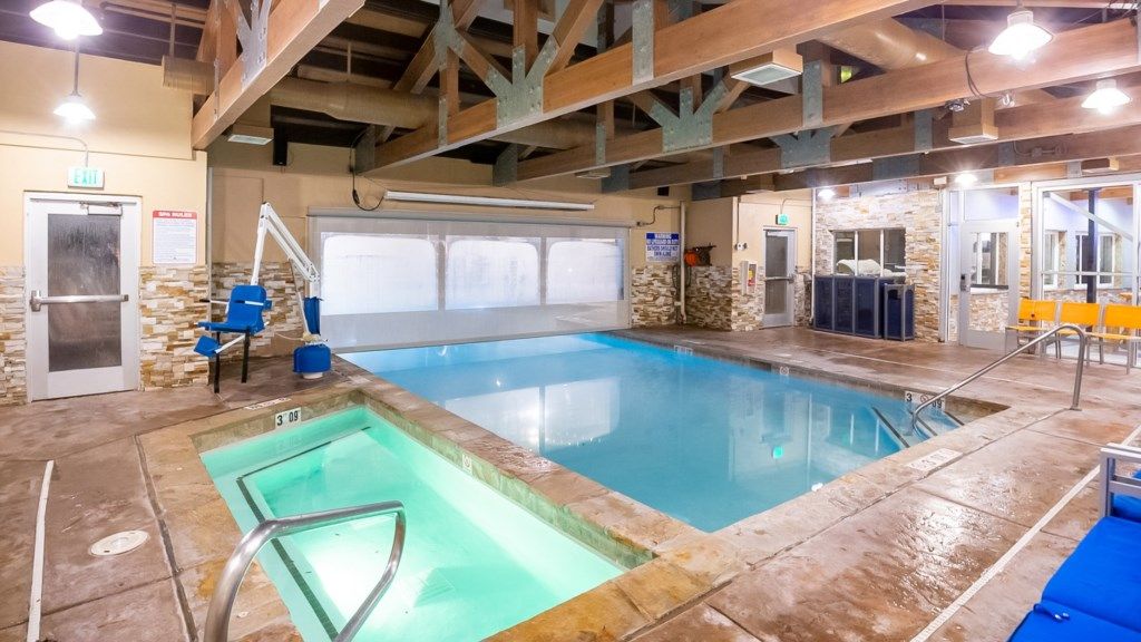 Una piscina interior con trampolín, vestuario y una zona de recepción.
