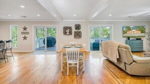 A spacious living area with a dining table, white chairs, a beige sofa, and a TV. - Almost There- Fire pit, dog friendly sleeps 6 (Moneta)