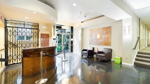 A lobby with a reception desk, two seating areas, and a staircase. - 20% Off July |City View + Parking |Walk to Downtown - Near Convention Center, Theaters & Stadiums (Seattle)