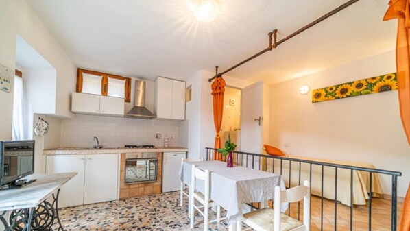 Cozy kitchenette with stove, sink, and dining area, perfect for preparing meals.