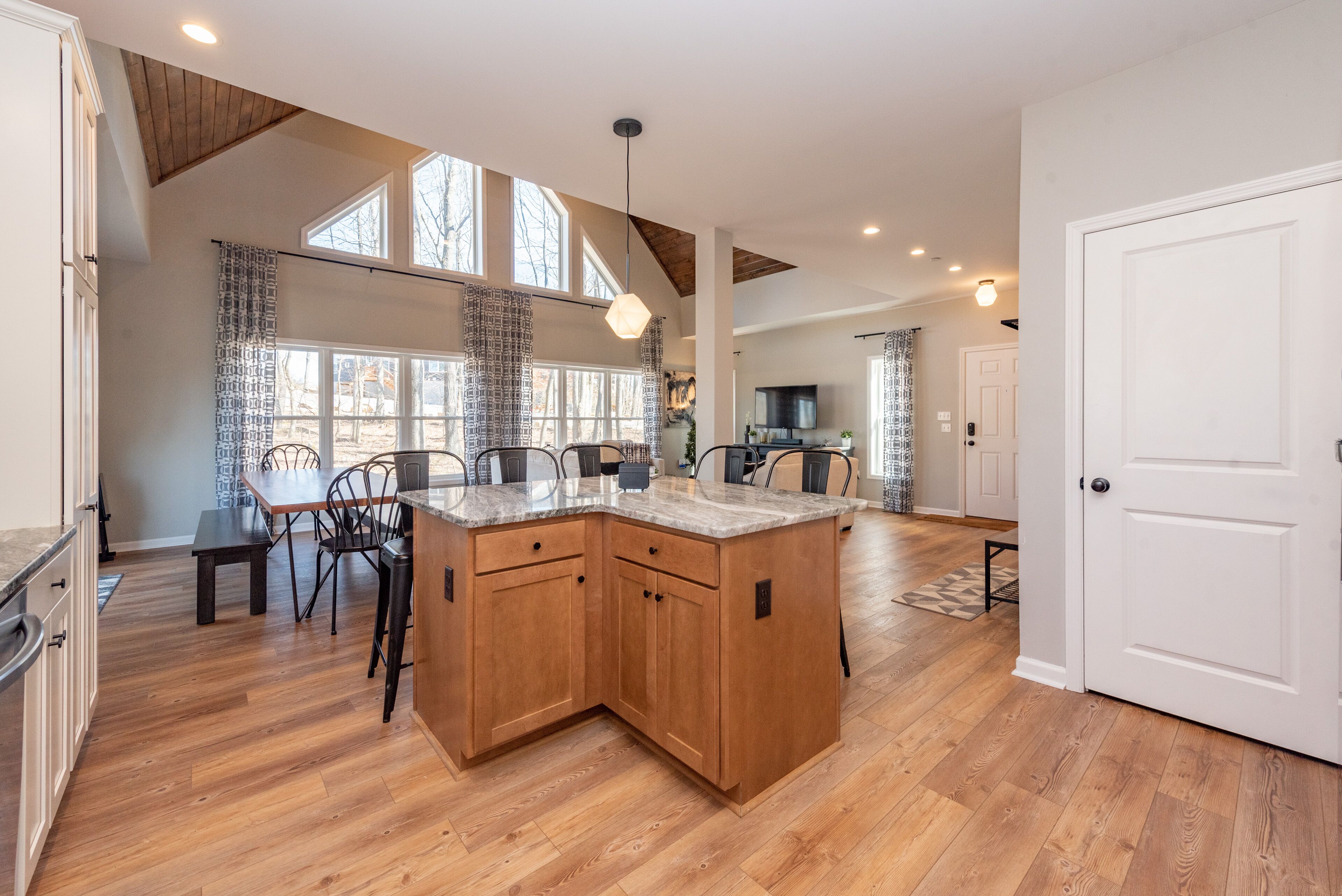A spacious kitchen with wooden cabinets, a large island, and a dining area with chairs.