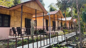 Un edificio de madera con porche cubierto, sendero de piedra y mobiliario exterior.