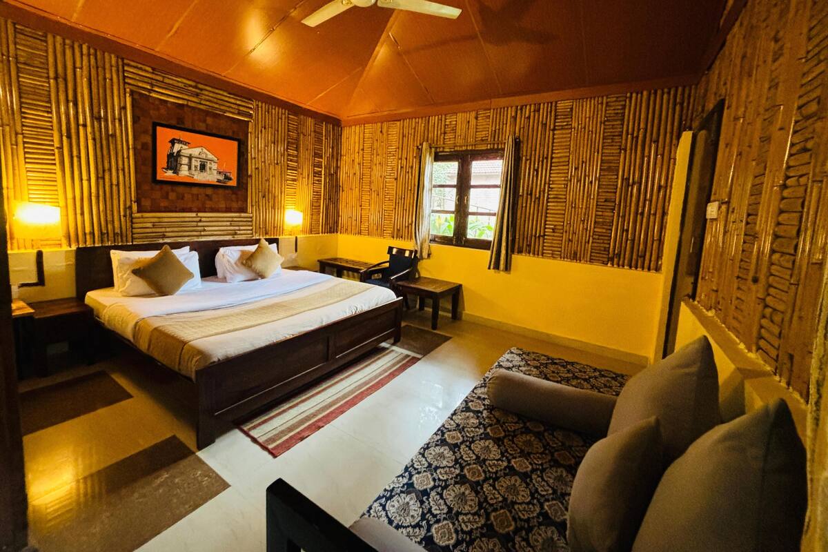 A bedroom with a bed, bedside tables, a chair, a window, and a ceiling fan.