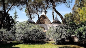 Un bâtiment doté de plusieurs toits coniques, entouré d’arbres et de verdure.