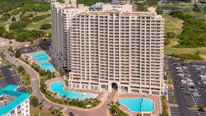 Un hôtel de grande hauteur doté de nombreux balcons, d’une cour intérieure et de deux piscines.