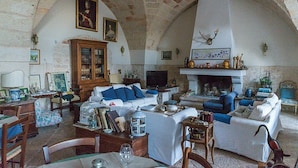 A cozy living room with a fireplace, comfortable seating, and a stone ceiling. - Casa Vega D: A welcoming cottage in the characteristic style of the Apulian countryside, with Free WI-FI. (San Vito dei Normanni)