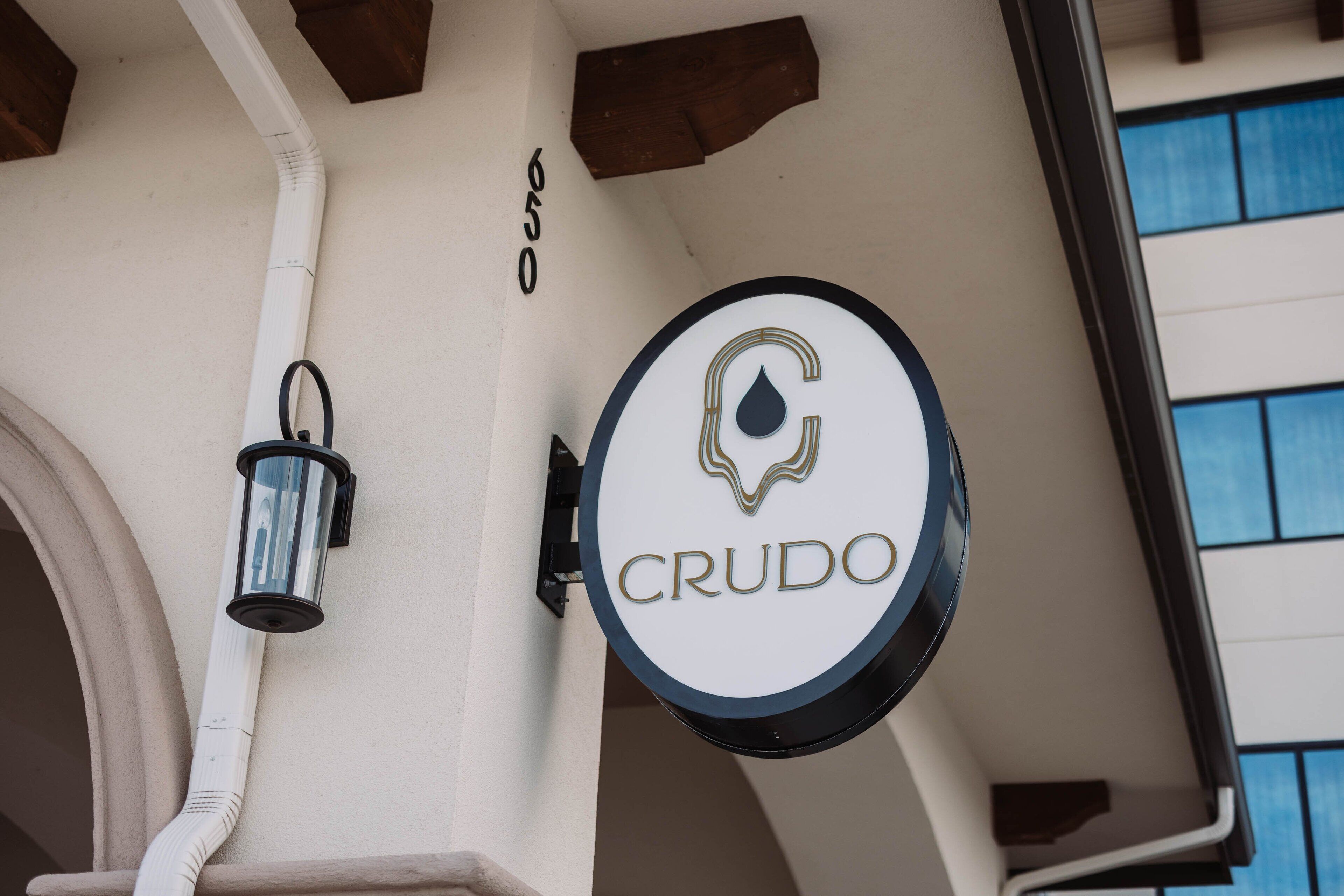 A building corner with a sign reading "CRUDO" and a number "650".
