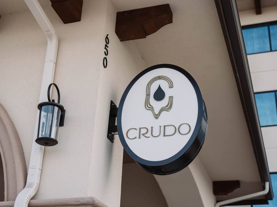 A building corner with a sign reading "CRUDO" and a number "650".