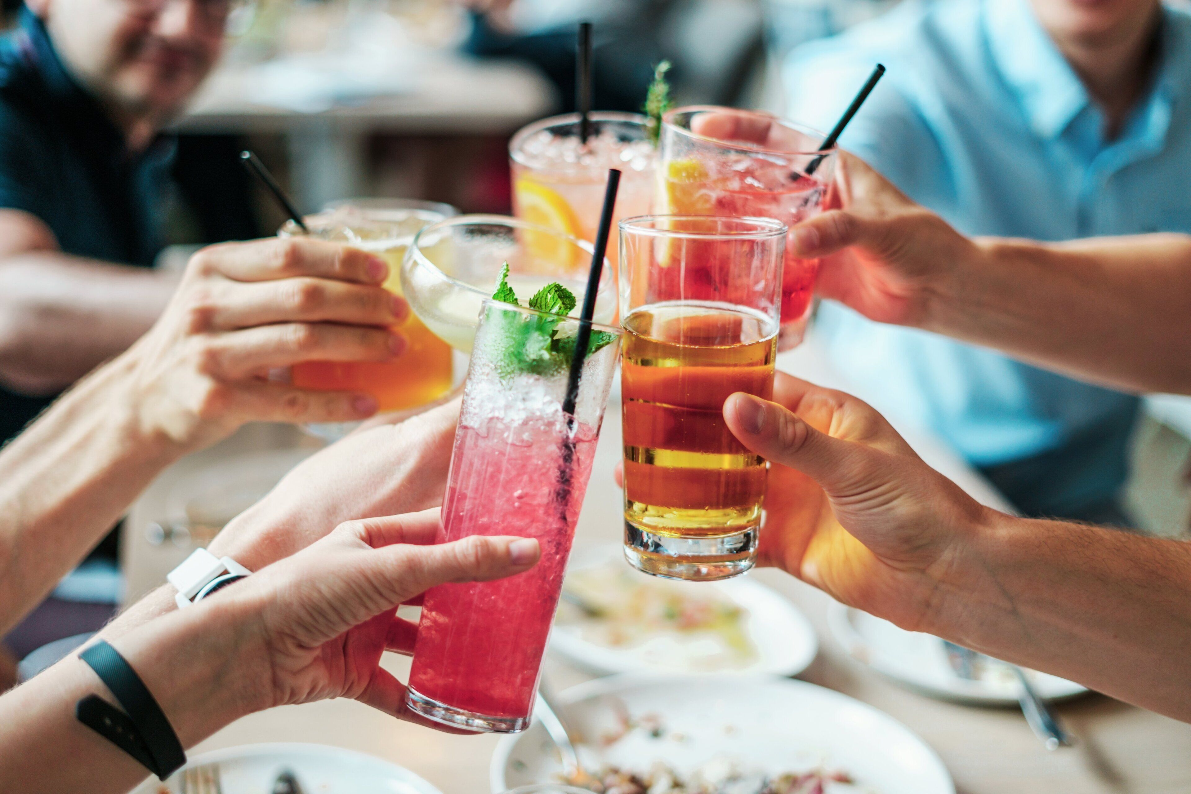 A group of people toasting with drinks, possibly at a social gathering or celebration.