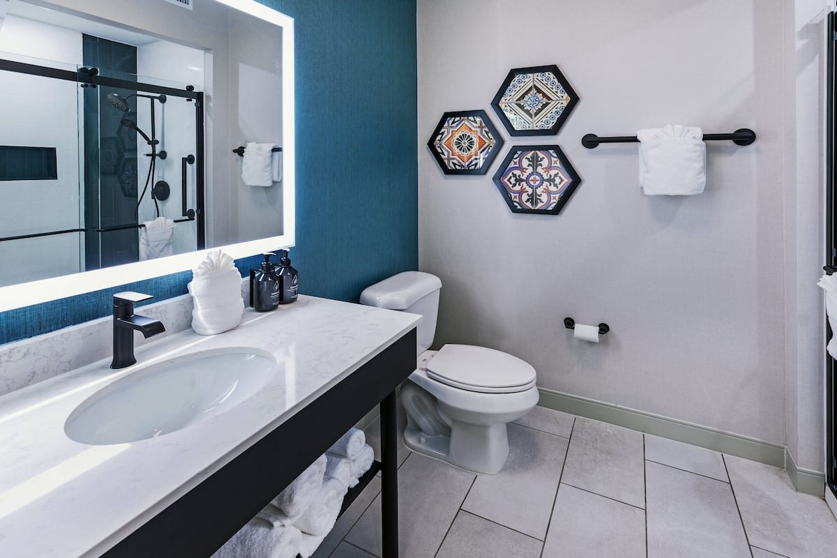 Un baño moderno con un lavamanos grande, inodoro y ducha.