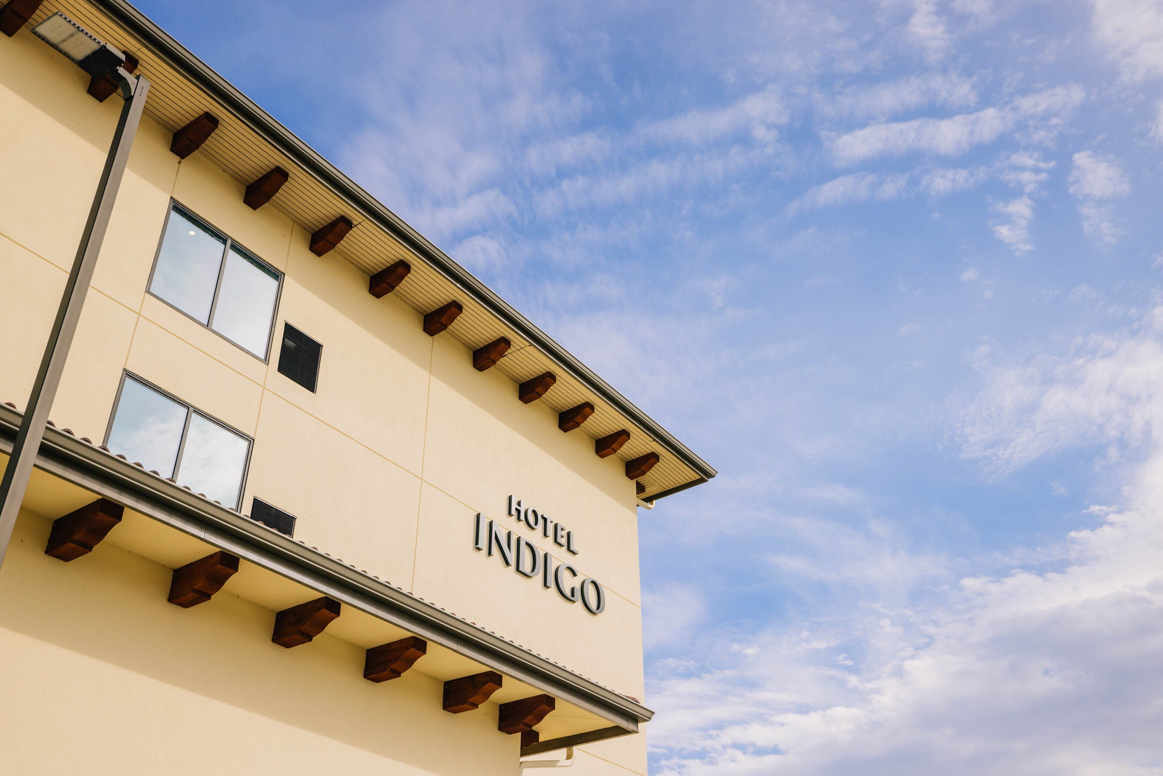 A building with the sign "Hotel Indigo" on its facade.