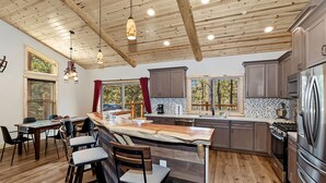 A spacious kitchen with wooden beams, a large island, and modern appliances.
