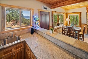 A kitchen with granite countertops, wooden cabinets, and a view of the outdoors.