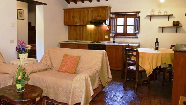 Una sala de estar acogedora con un sofá, una mesa de comedor y armarios de madera.