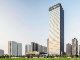 A high-rise hotel with a modern glass facade, surrounded by other high-rise buildings.