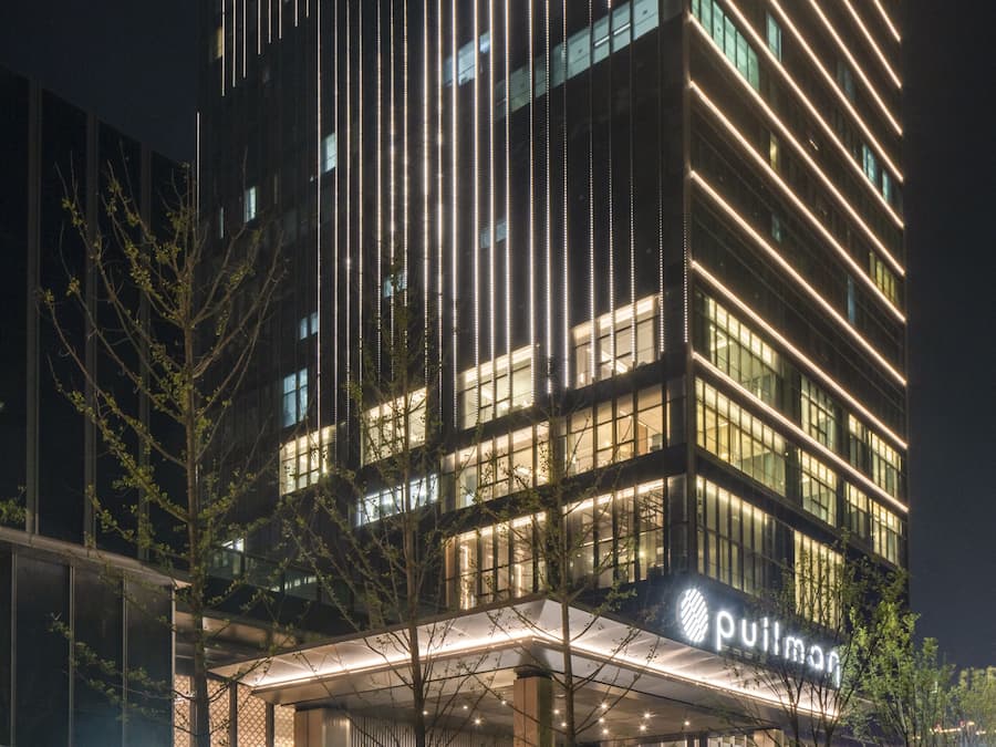 Un bâtiment d’hôtel doté d’une enseigne lumineuse et dont l’extérieur est bien entretenu.