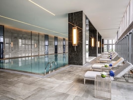 Una piscina techada, sillones reclinables de piscina