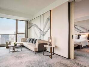 A modern hotel room with a large bed, a sofa, a small table, and a large window offering a city view. - Pullman Jiaxing Pinghu Excellence (Jiaxing)