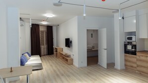 Un appartement moderne comprenant un espace de vie, une kitchenette et une chambre.